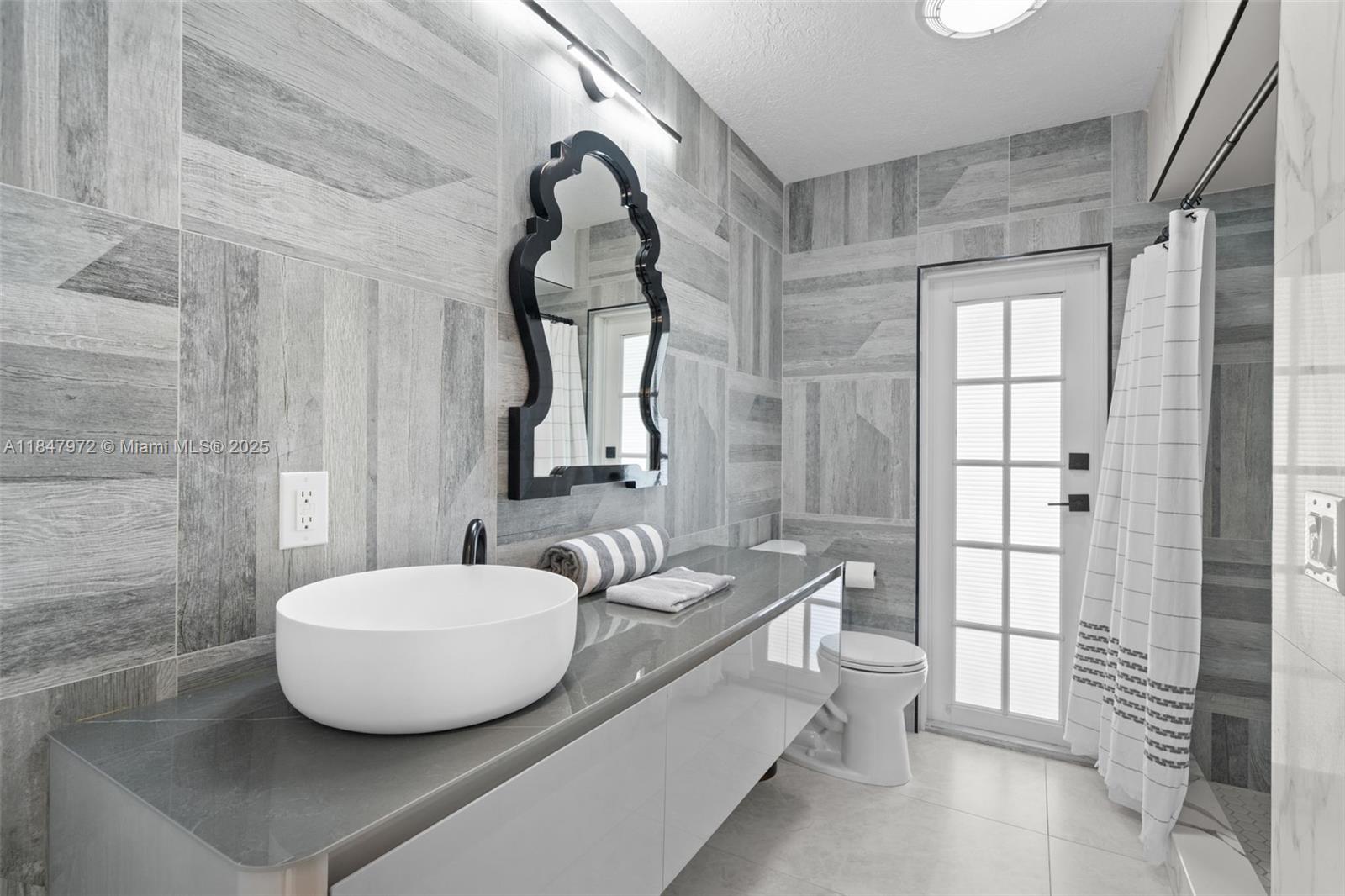 2681 Northeast 9th Court Pompano Beach, FL 33062 - Photo 32 of 58 a bathroom with a granite countertop sink a mirror and shower