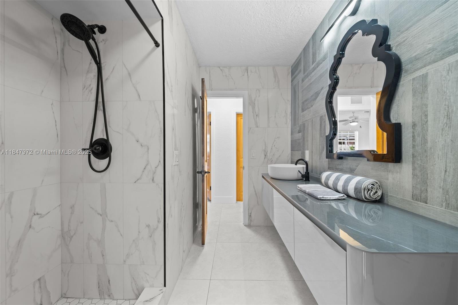 2681 Northeast 9th Court Pompano Beach, FL 33062 - Photo 33 of 58 a en suite bathroom with a granite countertop vanity and mirror