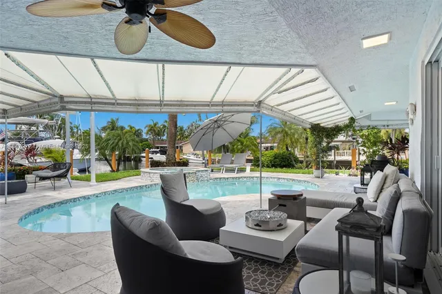 a swimming pool with table and chairs under an umbrella