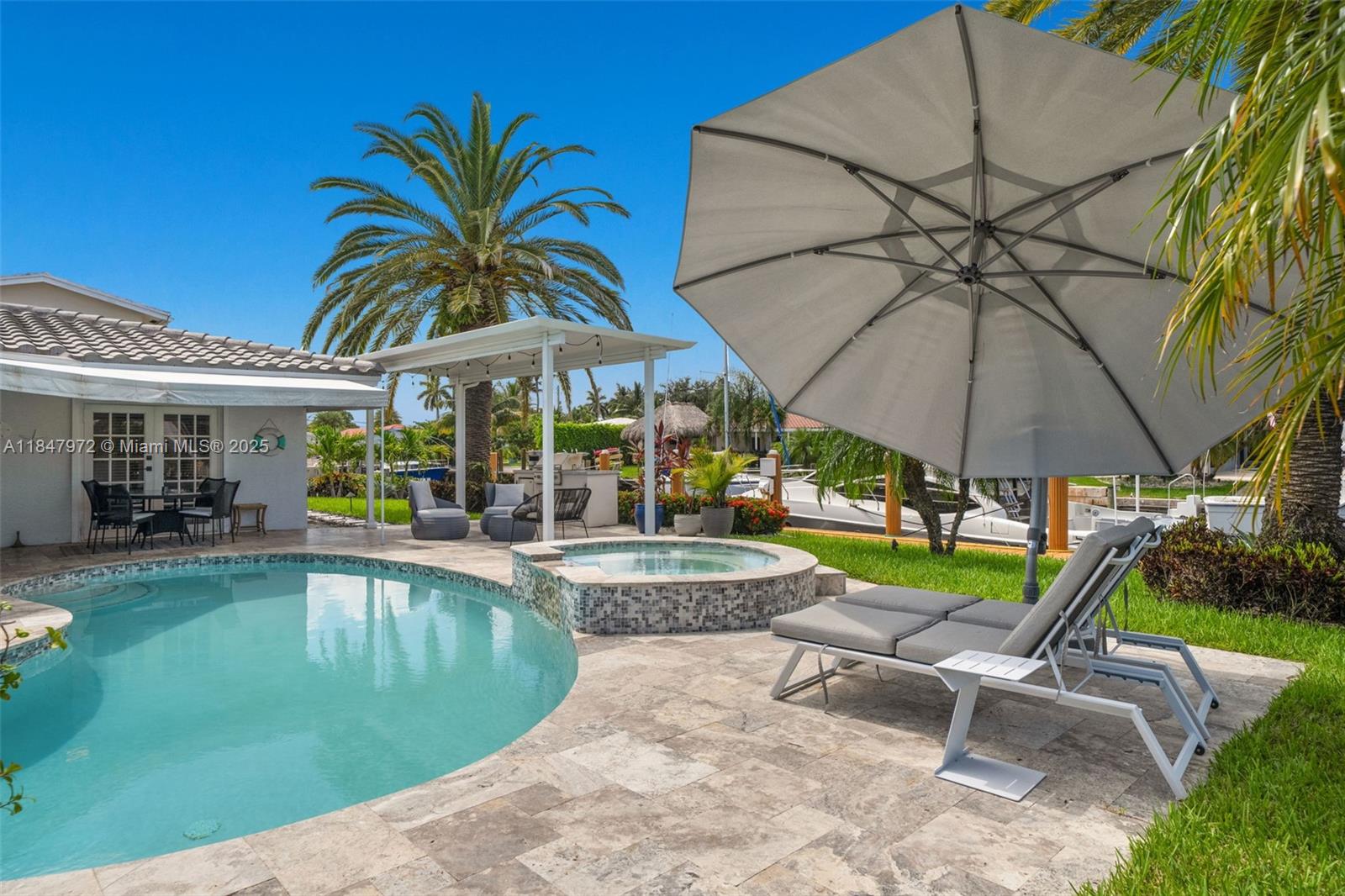 2681 Northeast 9th Court Pompano Beach, FL 33062 - Photo 36 of 58 a swimming pool with table and chairs under an umbrella