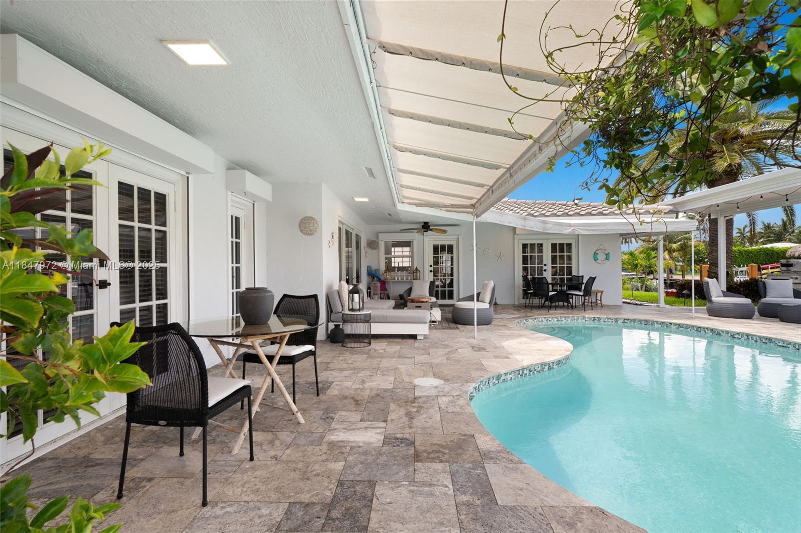 2681 Northeast 9th Court Pompano Beach, FL 33062 - Photo 7 of 58 a swimming pool with outdoor seating and yard
