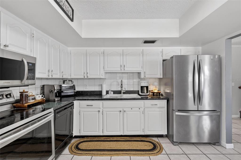 6609 Jennifer Drive Temple Terrace, FL 33617 - Photo 19 of 49 a kitchen with granite countertop a refrigerator stove and microwave