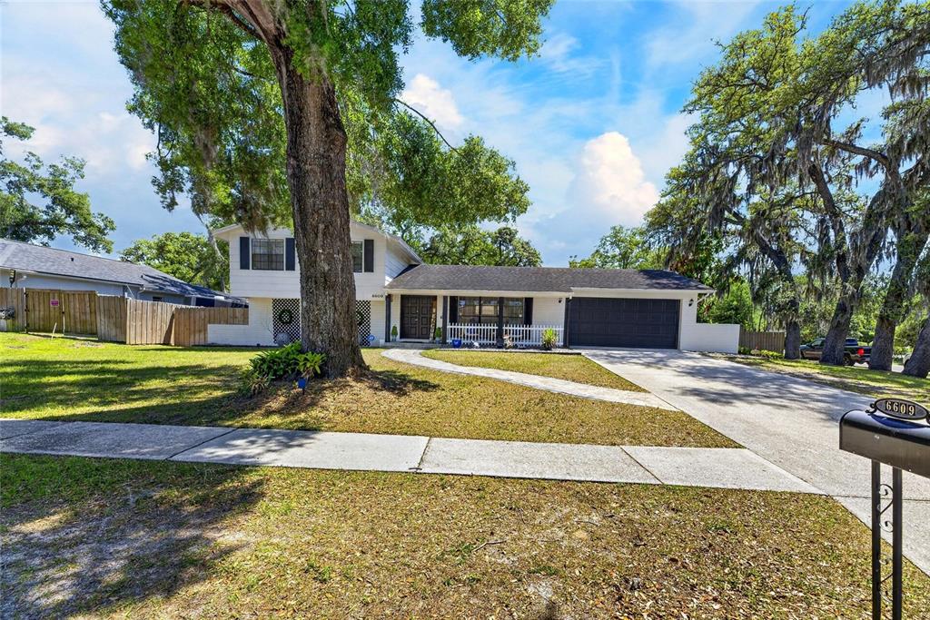 6609 Jennifer Drive Temple Terrace, FL 33617 - Photo 4 of 49 a front view of a house with a garden and trees