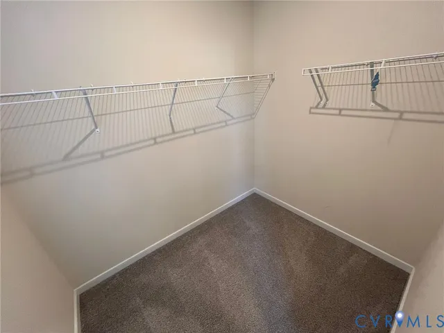 an empty room with windows and ceiling fan