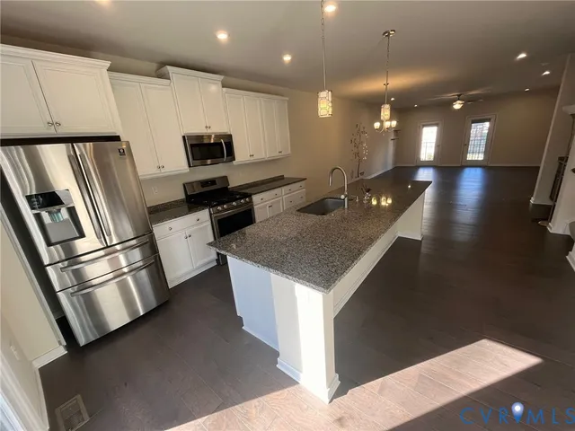 an empty room with windows and ceiling fan