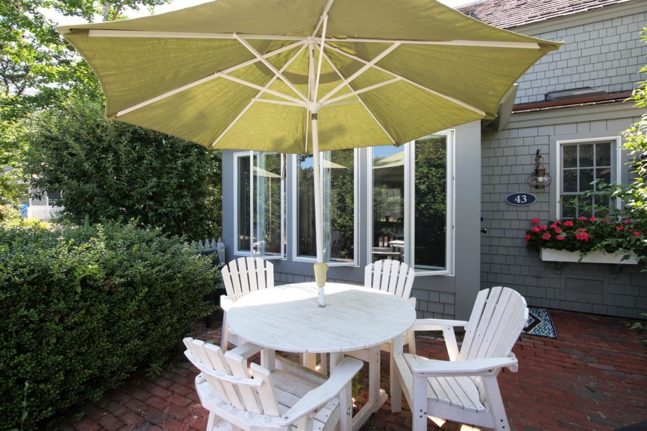 43 Brant Rock Road, Unit 43 Mashpee, MA 02649 - Photo 12 of 16 a patio with a table and chairs under an umbrella