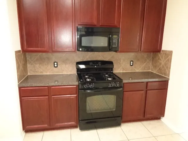 a kitchen with stainless steel appliances wooden cabinets and a stove top oven