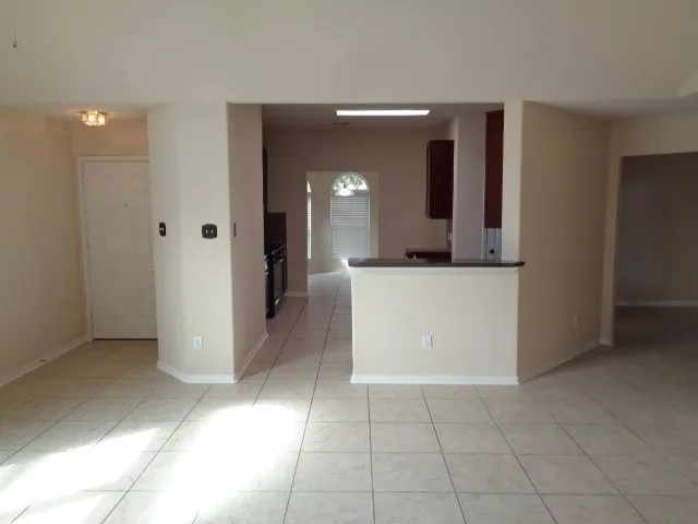 a view of a hallway with wooden floor and a living room