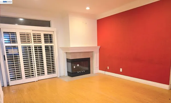 a view of an empty room with a fireplace and a window