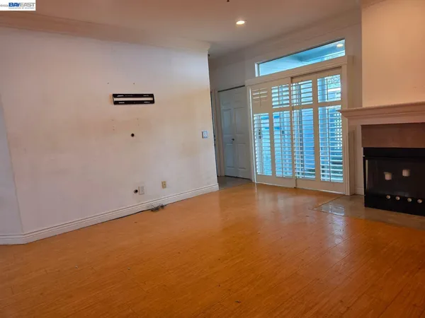 a view of an empty room with a fireplace and a window