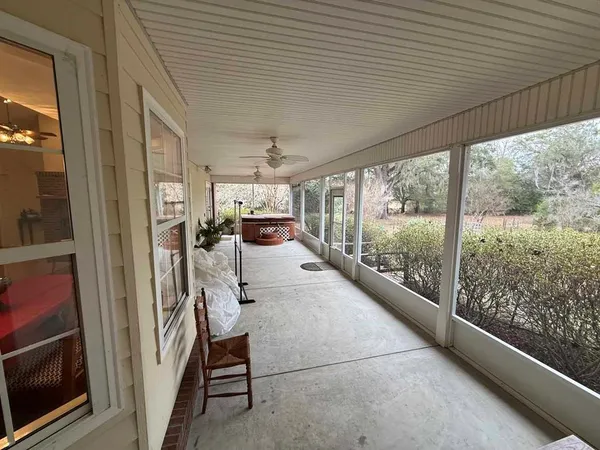 a view of a hallway with wooden floor and furniture