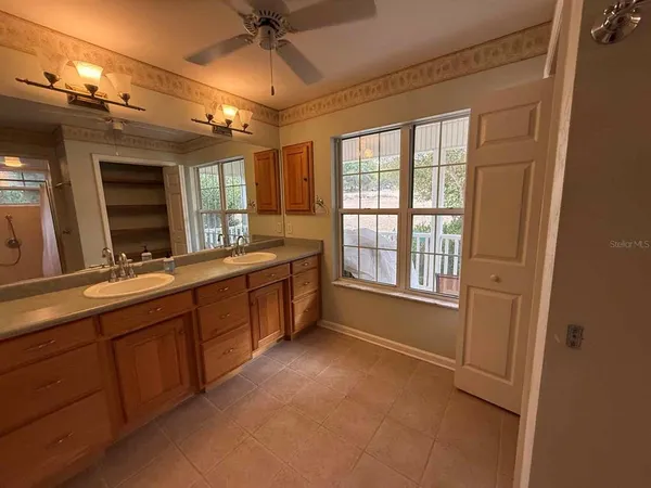 a spacious bathroom with a double vanity sink a large mirror and a bathtub