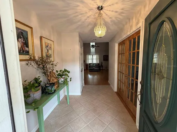 a hall way with furniture and a chandelier