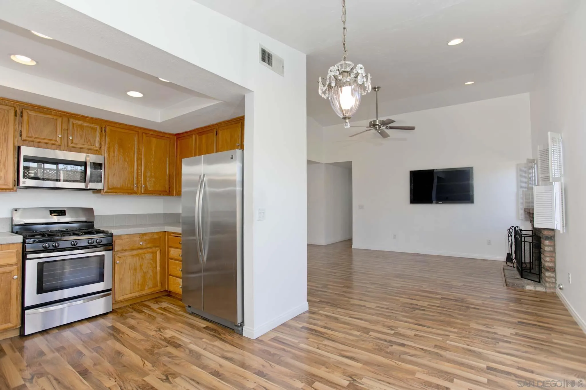 10076 West Glendon Circle Santee, CA 92071 - Photo 12 of 35 a kitchen with stainless steel appliances granite countertop a refrigerator a stove a sink dishwasher and a refrigerator with wooden floor