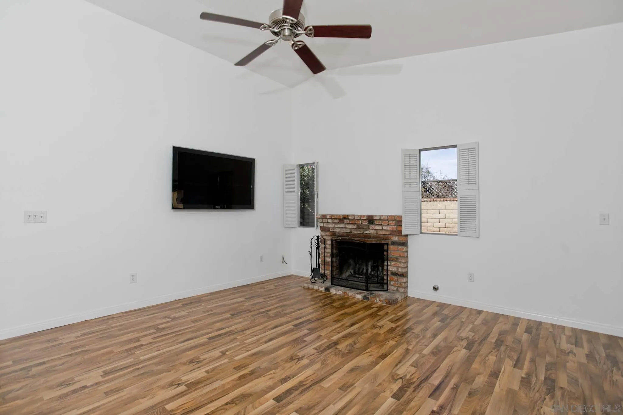 10076 West Glendon Circle Santee, CA 92071 - Photo 14 of 35 a view of a livingroom with wooden floor a ceiling fan and a window