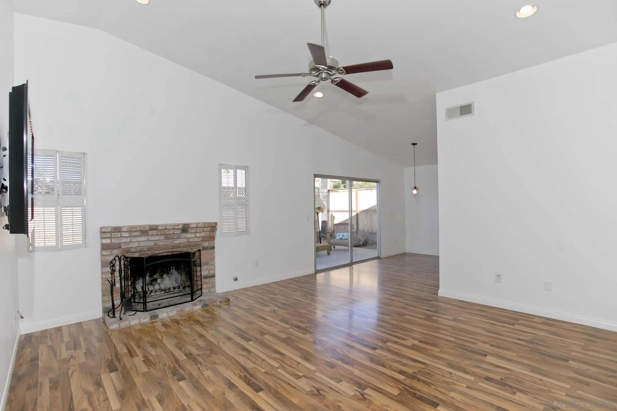 10076 West Glendon Circle Santee, CA 92071 - Photo 4 of 35 a view of an empty room with wooden floor fireplace and a window