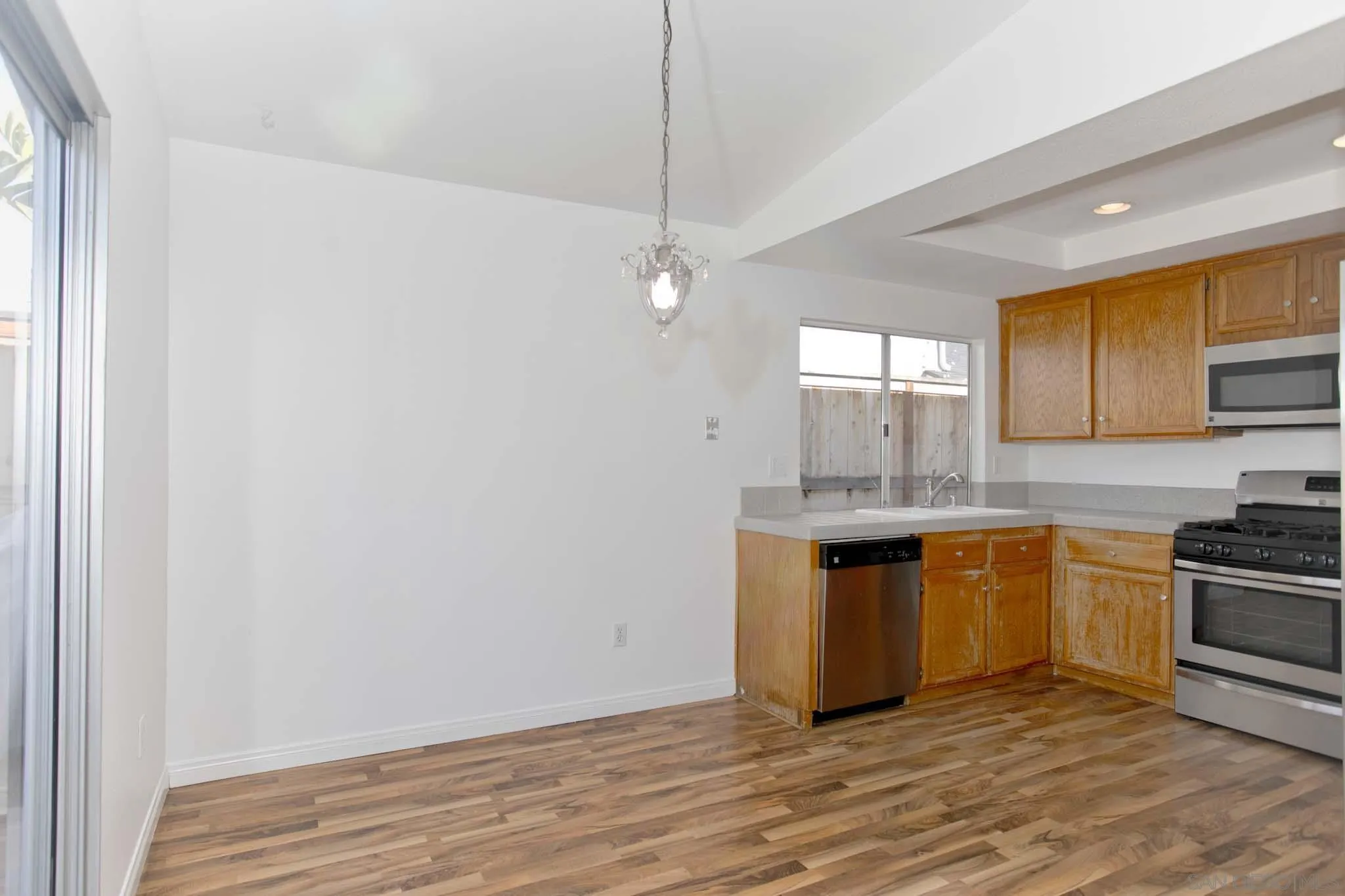 10076 West Glendon Circle Santee, CA 92071 - Photo 8 of 35 a kitchen with stainless steel appliances granite countertop a sink and cabinets with wooden floor