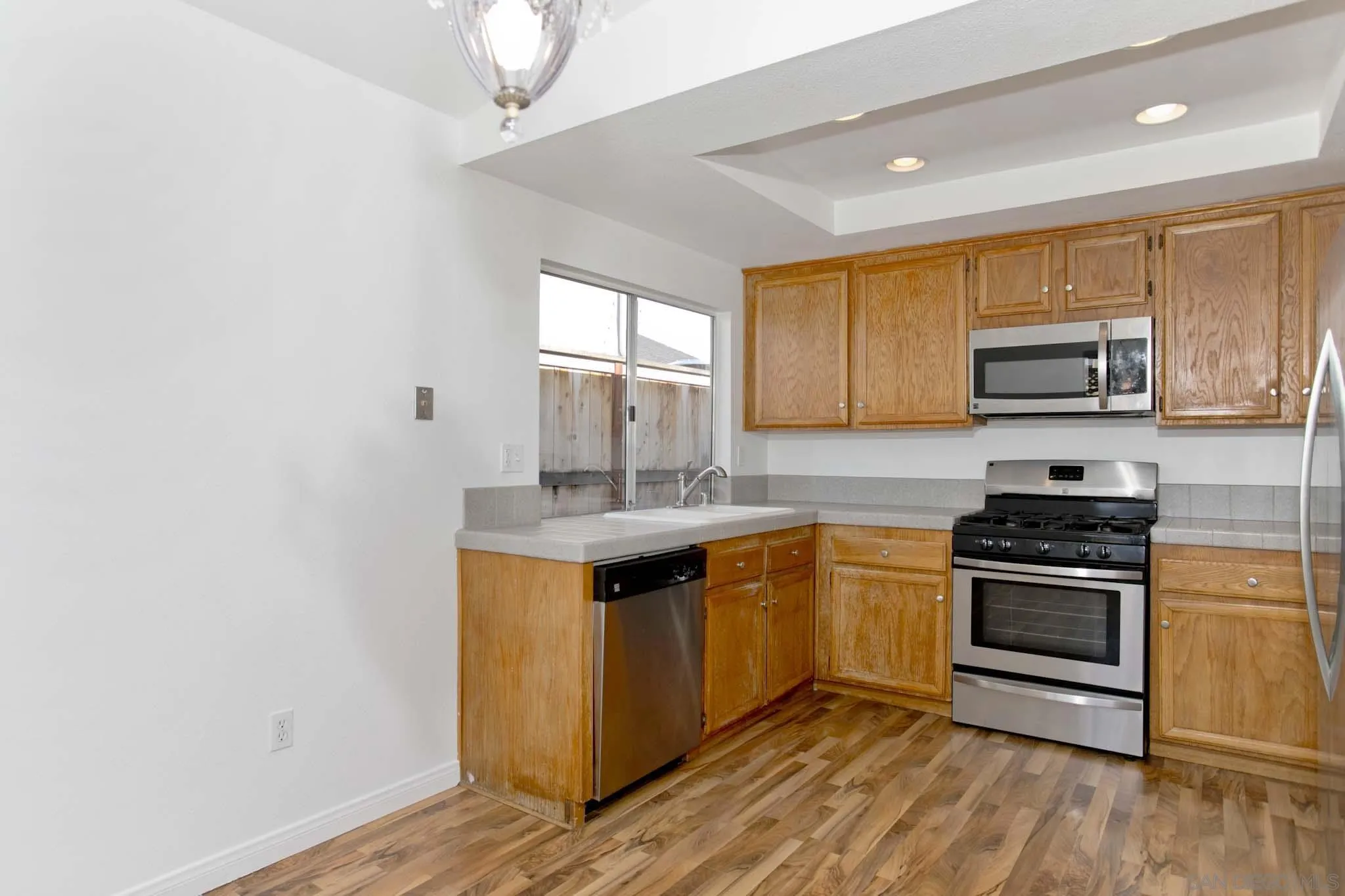 10076 West Glendon Circle Santee, CA 92071 - Photo 9 of 35 a kitchen with stainless steel appliances granite countertop a stove a sink and a microwave