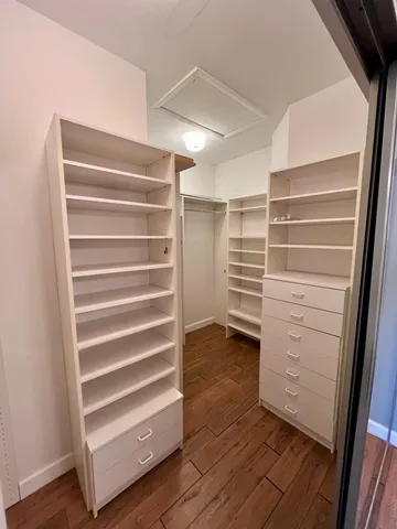 a view of walk in closet with empty racks
