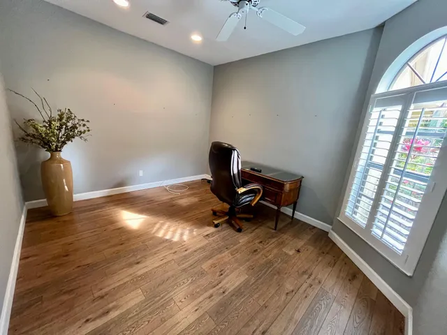 a view of a workspace with furniture and a window