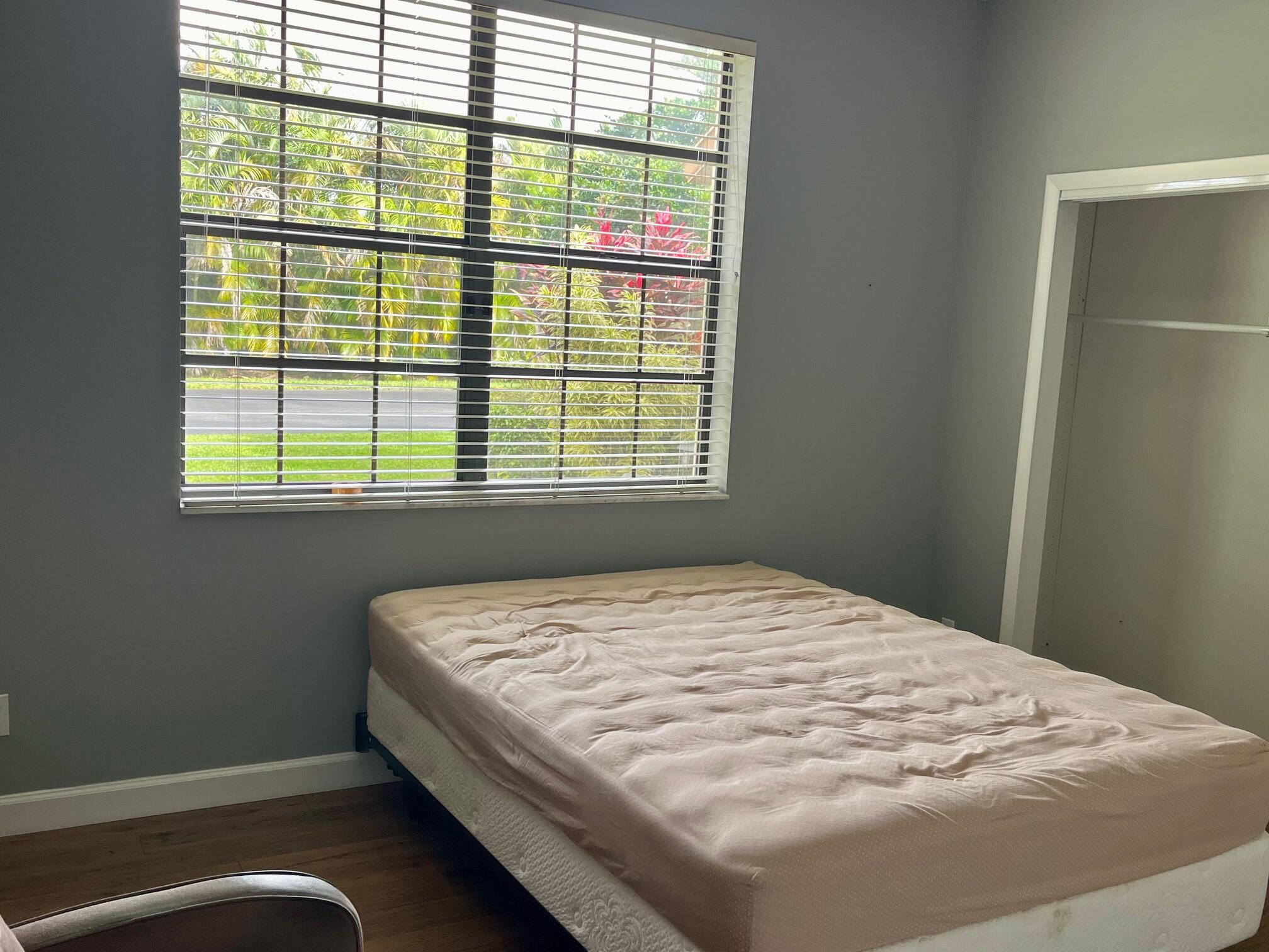 8300 Waterline Drive, Unit 105 Boynton Beach, FL 33472 - Photo 15 of 20 a bed sitting in a bedroom next to a window