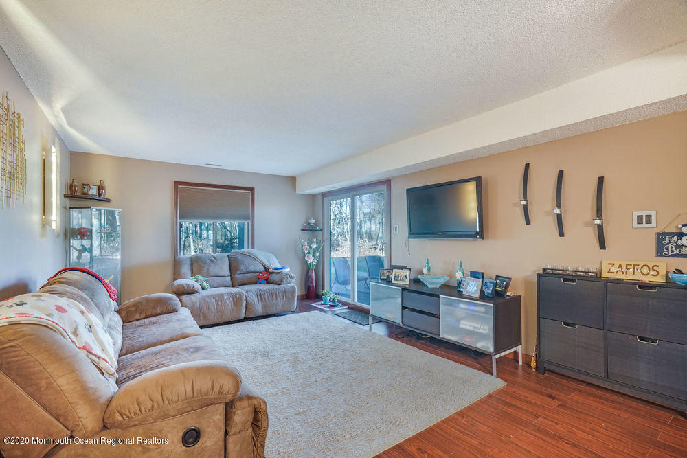 89 Northrup Drive, Unit 75 Brick, NJ 08724 - Photo 2 of 24 a living room with furniture and a flat screen tv