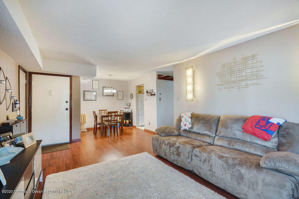 89 Northrup Drive, Unit 75 Brick, NJ 08724 - Photo 11 of 24 a living room with furniture and a dining table with wooden floor