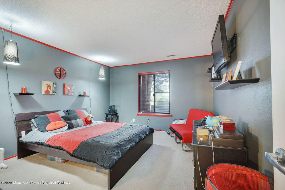 89 Northrup Drive, Unit 75 Brick, NJ 08724 - Photo 16 of 24 a bedroom with a bed and a chandelier