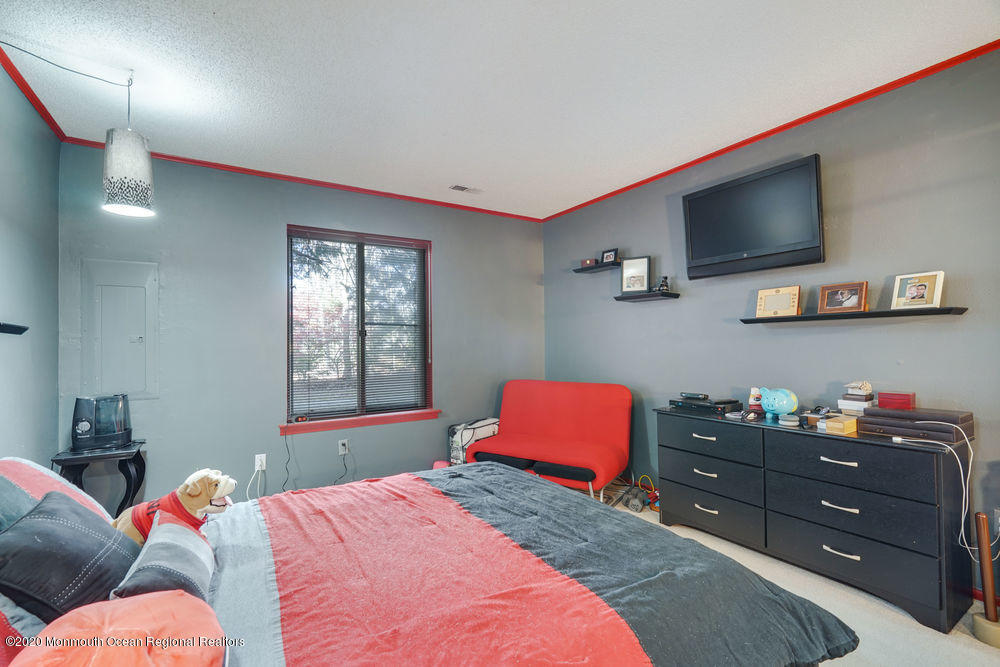 89 Northrup Drive, Unit 75 Brick, NJ 08724 - Photo 17 of 24 a bedroom with a bed and flat screen tv