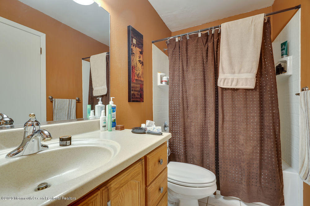 89 Northrup Drive, Unit 75 Brick, NJ 08724 - Photo 19 of 24 a bathroom with a sink a toilet and a mirror