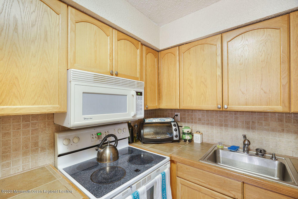 89 Northrup Drive, Unit 75 Brick, NJ 08724 - Photo 7 of 24 a kitchen with a sink a stove and cabinets