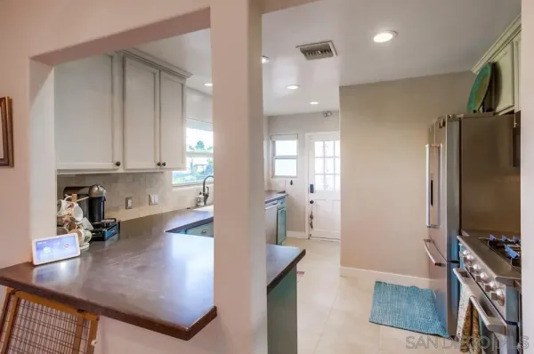 a room with stainless steel appliances granite countertop a refrigerator and a sink