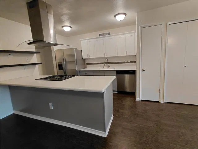 a large kitchen with cabinets a sink and a stove