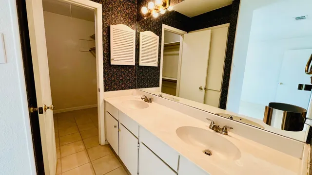 a bathroom with a double vanity sink and a mirror