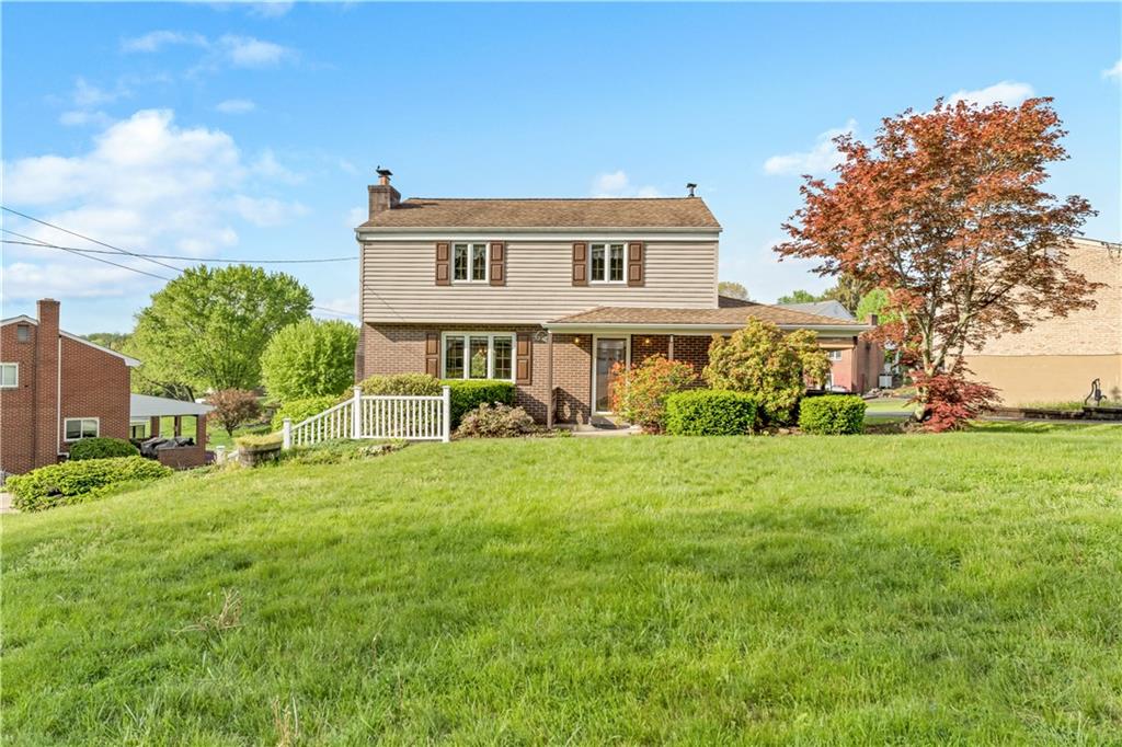 a view of a house with a big yard plants and large trees