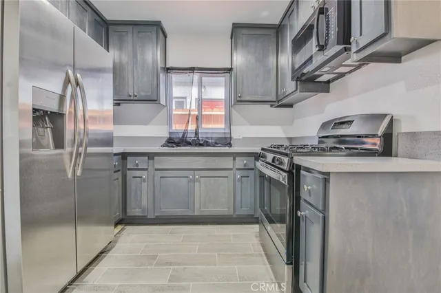 a kitchen with stainless steel appliances granite countertop a stove a sink and a refrigerator