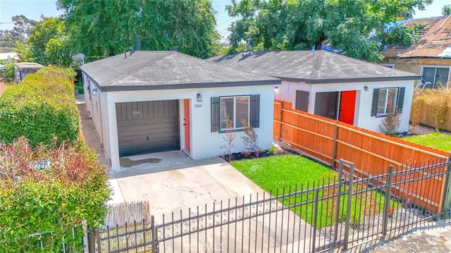 a aerial view of a house with yard and trees in the background