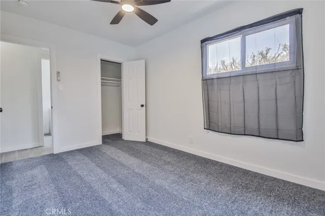 a view of an empty room with ceiling fan