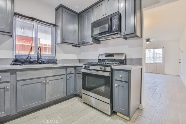 a kitchen with stainless steel appliances granite countertop a stove microwave and sink