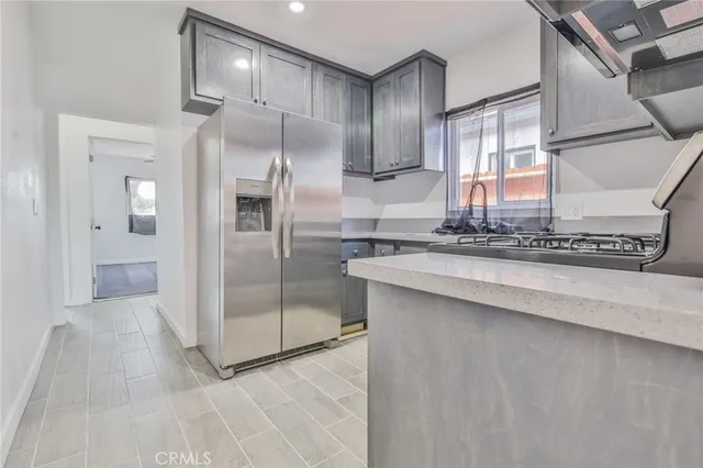 a kitchen with stainless steel appliances granite countertop a refrigerator and a sink