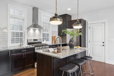 a kitchen with stainless steel appliances granite countertop a stove a sink dishwasher and a wooden cabinets