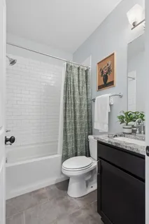 a bathroom with a granite countertop sink a toilet and a bathtub