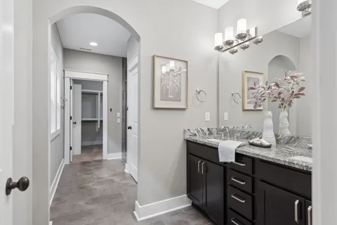a bathroom with double vanity sinks a vanity a lamp and a mirror