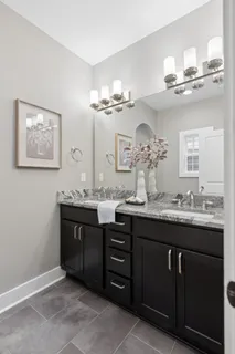 a bathroom with a granite countertop sink a large mirror and cabinets