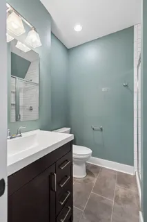 a bathroom with a sink a toilet and a mirror