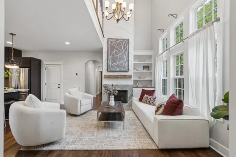 a living room with fireplace furniture and a large window