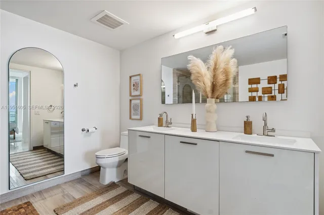 a bathroom with a toilet sink and mirror
