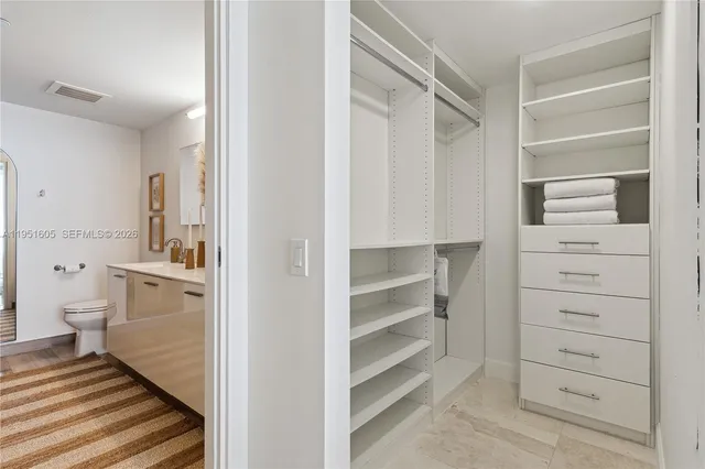 a view of walk in closet and bedroom