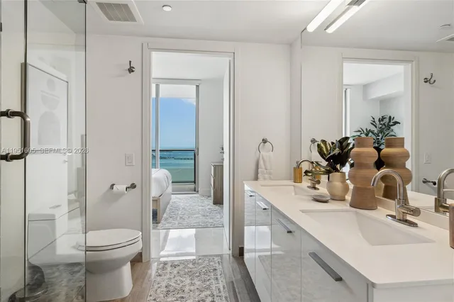 a bathroom with a double vanity sink toilet and shower
