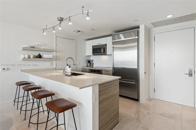 a kitchen with kitchen island a sink stove and refrigerator